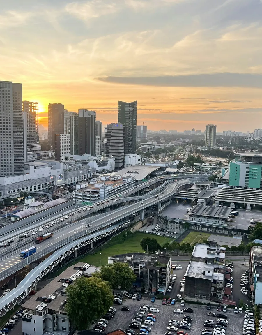 Johor Bahru city centre at sunset, with elevated highways and high-rise offices.